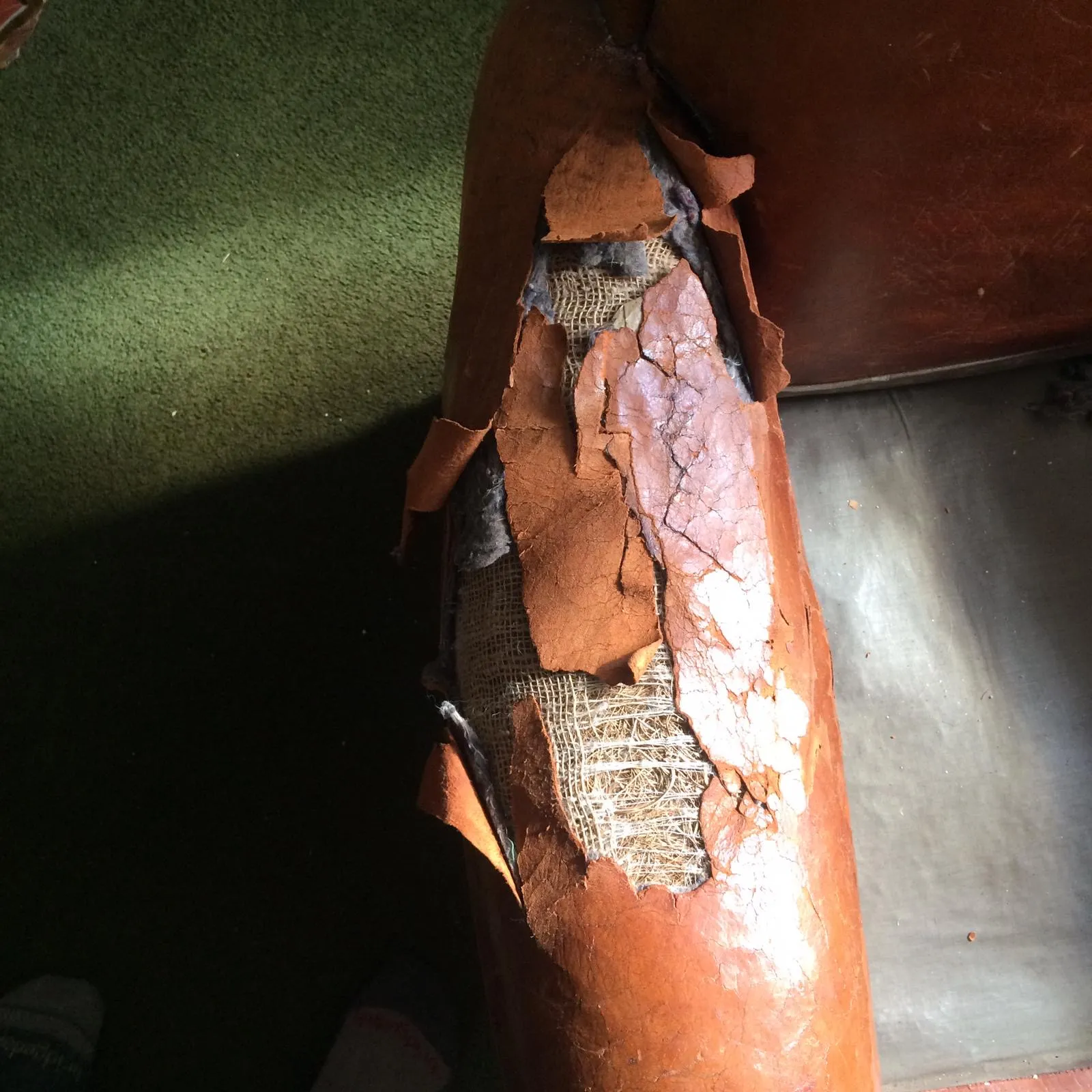 Damaged leather arm panels on the antique French armchairs